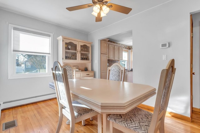 dining space featuring a baseboard radiator, light wood-type flooring, and ceiling fan