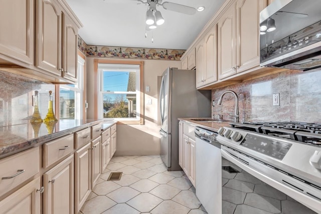 kitchen featuring sink, light stone counters, ceiling fan, and appliances with stainless steel finishes