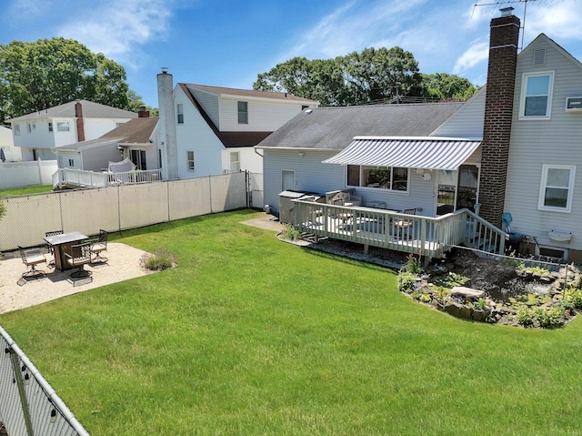 back of house with a wooden deck, a patio area, and a yard