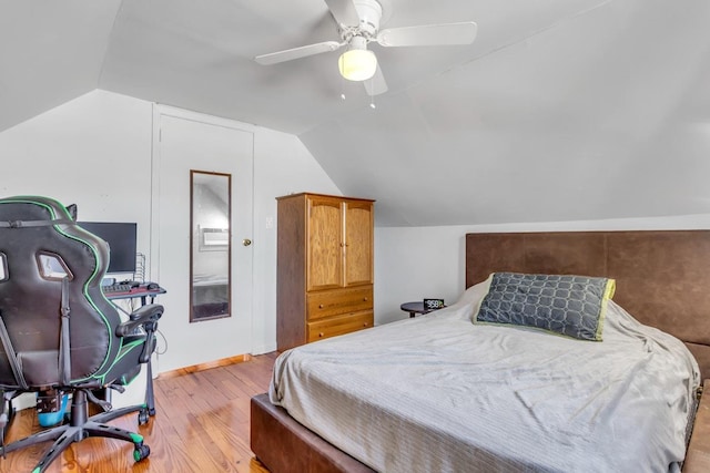 bedroom featuring light hardwood / wood-style floors, ceiling fan, and vaulted ceiling