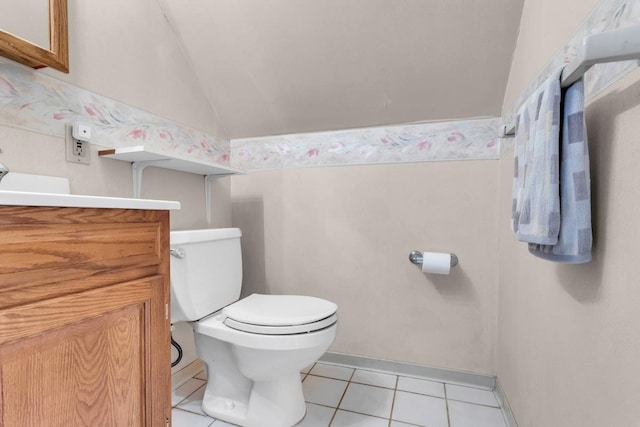 bathroom with tile patterned floors, toilet, vanity, and vaulted ceiling