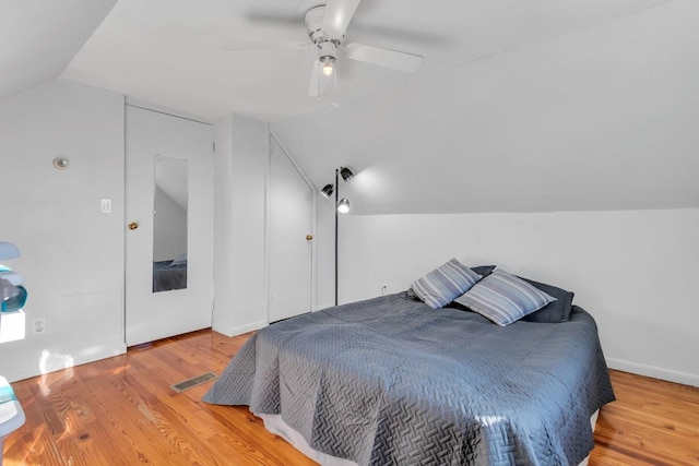 bedroom featuring ceiling fan, light hardwood / wood-style floors, and lofted ceiling