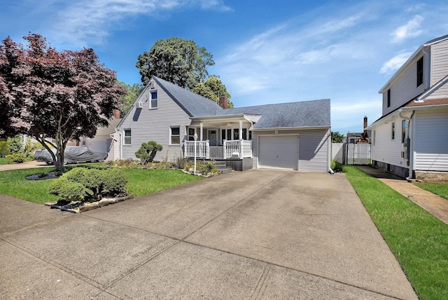 view of front of home with covered porch, a garage, and a front lawn