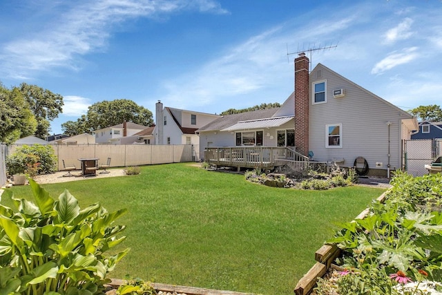 rear view of property featuring a wooden deck and a lawn