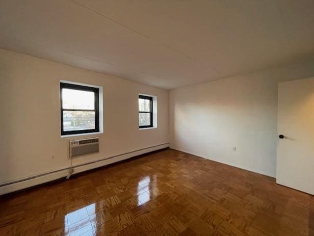 empty room with a baseboard radiator, a wall mounted AC, and dark parquet floors