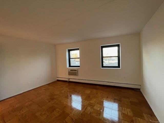 empty room featuring a baseboard heating unit and parquet flooring