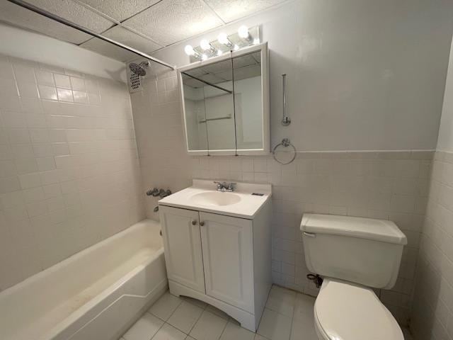 full bathroom featuring toilet, tile walls, shower / tub combination, tile patterned floors, and vanity