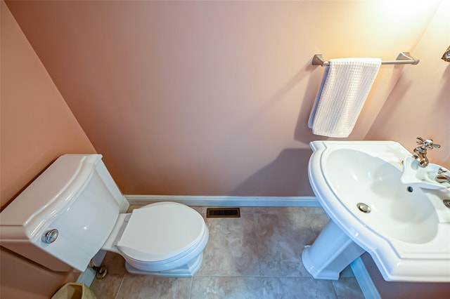 bathroom featuring toilet, sink, and tile patterned floors