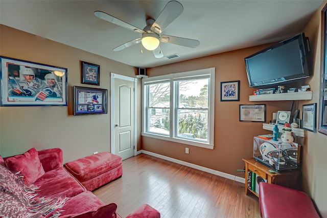 living room featuring ceiling fan and hardwood / wood-style floors