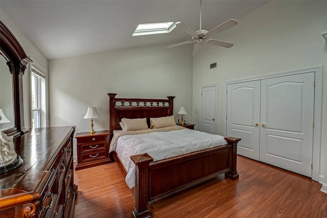 bedroom with dark wood-type flooring, ceiling fan, and lofted ceiling with skylight