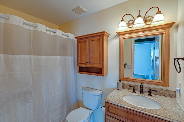 bathroom with toilet, vanity, and walk in shower