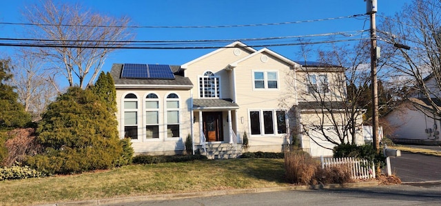 front of property with a front lawn and solar panels