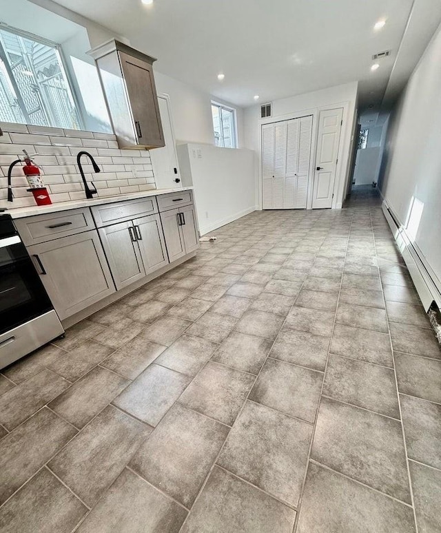 kitchen featuring range, backsplash, and sink