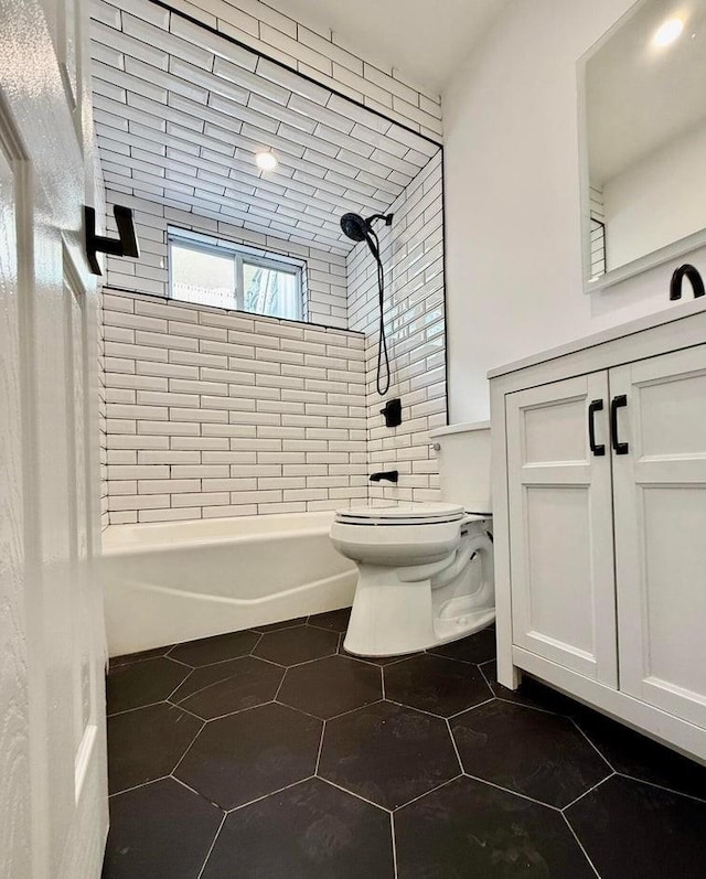 bathroom featuring toilet, tile patterned flooring, and tiled shower / bath combo