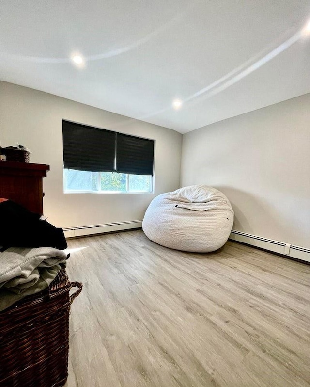 sitting room featuring light wood-type flooring and a baseboard heating unit