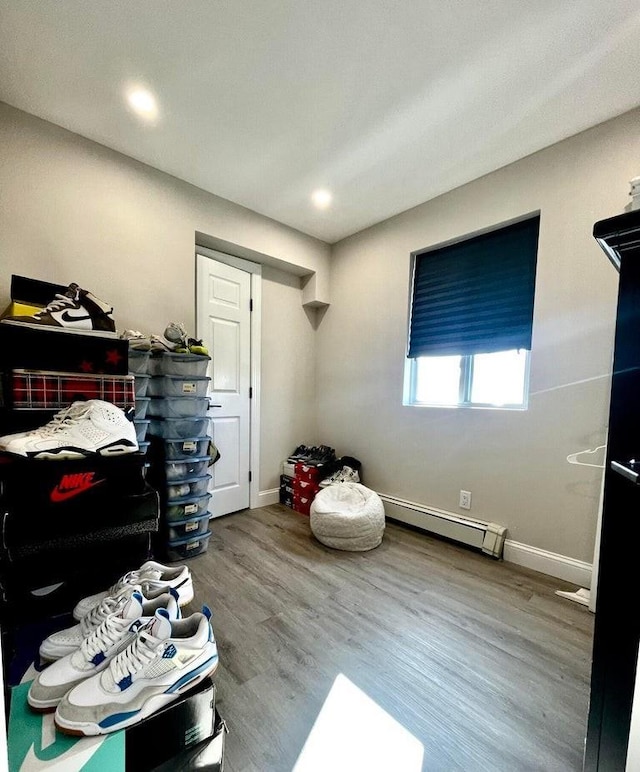 bedroom with wood-type flooring and baseboard heating