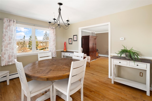 dining space featuring a baseboard heating unit, a chandelier, and light wood-type flooring