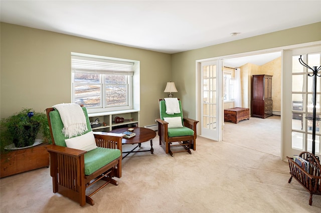 sitting room with light carpet, a baseboard radiator, and french doors