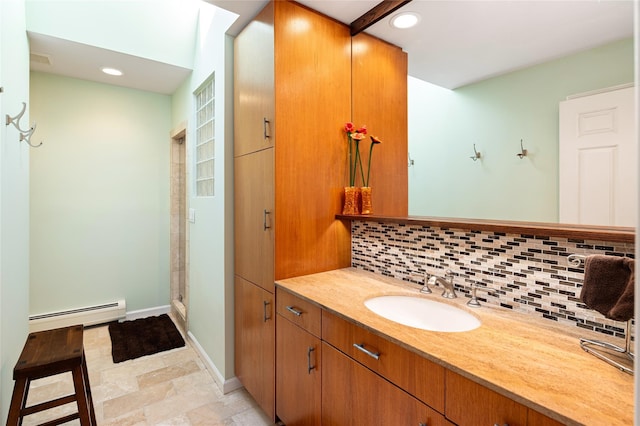 bathroom featuring vanity, backsplash, baseboard heating, and walk in shower