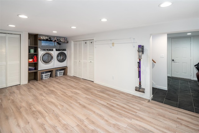 clothes washing area with washer and dryer and light hardwood / wood-style flooring