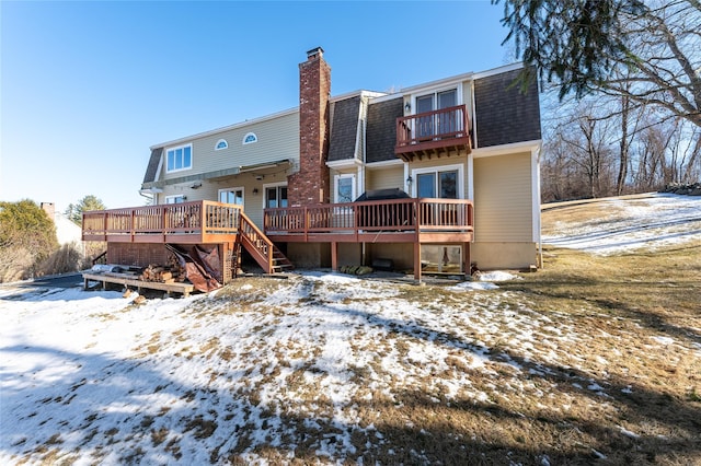 snow covered house with a wooden deck