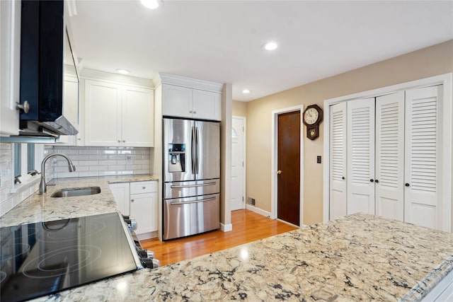 kitchen featuring tasteful backsplash, stainless steel appliances, white cabinets, and light stone counters