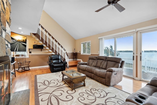 living room with ceiling fan, wood-type flooring, a water view, and vaulted ceiling