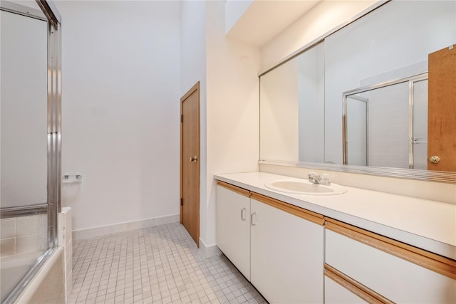 bathroom featuring enclosed tub / shower combo, vanity, and tile patterned flooring