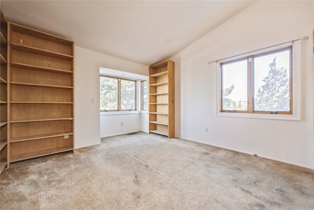 unfurnished bedroom featuring vaulted ceiling and light colored carpet