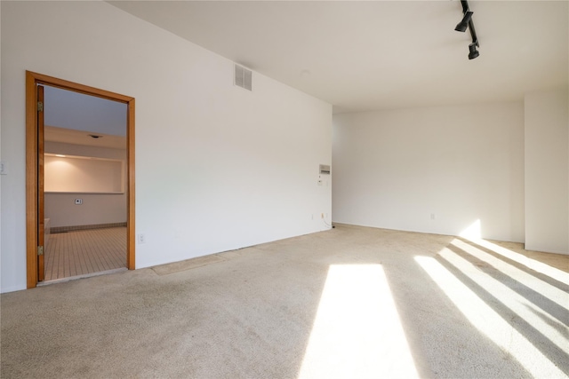 carpeted spare room with track lighting