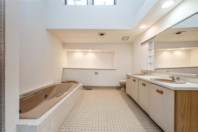 bathroom with vanity, tile patterned floors, tiled bath, and toilet