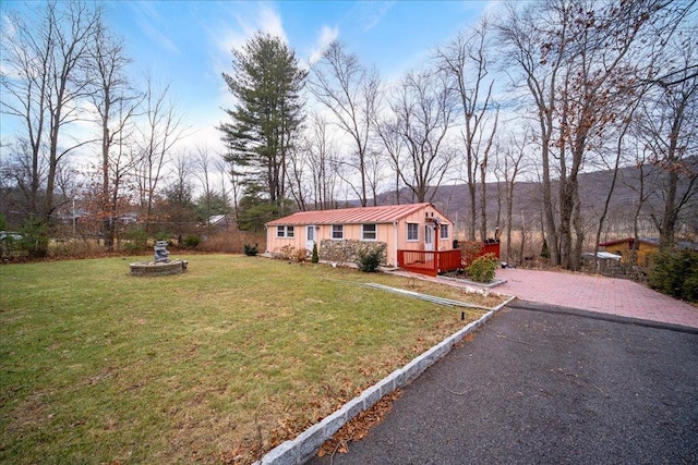 view of front of home with a front yard and a deck