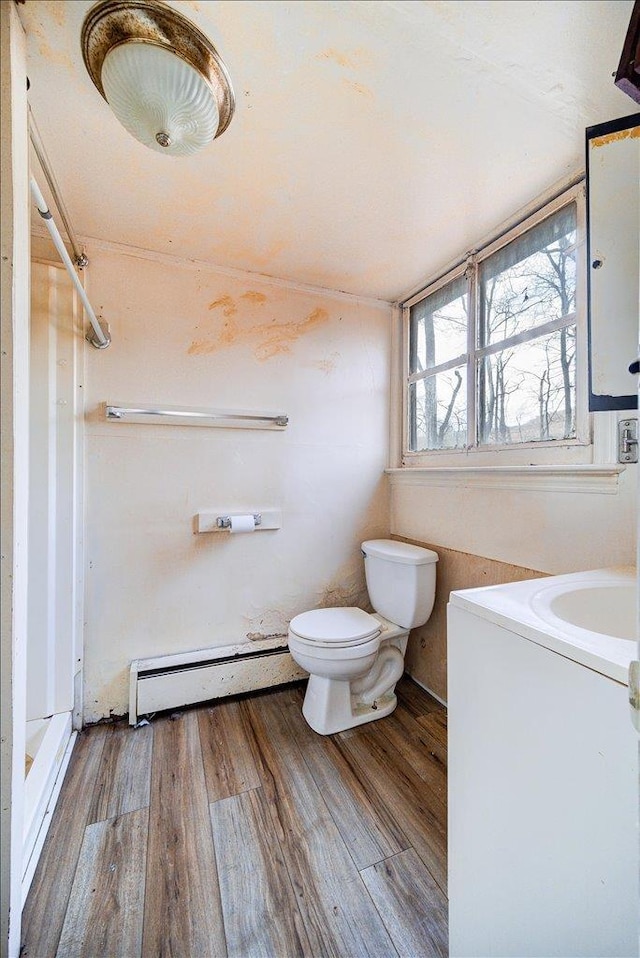 bathroom with toilet, hardwood / wood-style floors, vanity, and a baseboard radiator