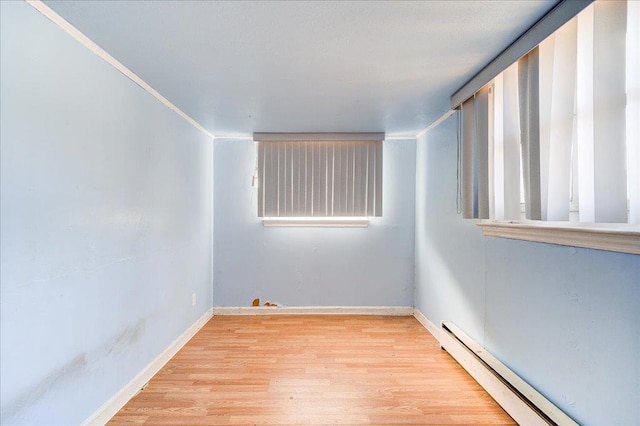 empty room with a baseboard radiator and light hardwood / wood-style flooring