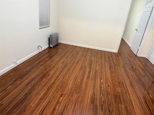 unfurnished room with radiator and dark hardwood / wood-style flooring