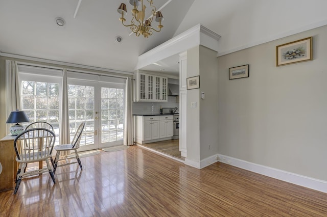 dining room featuring hardwood / wood-style flooring, lofted ceiling, and an inviting chandelier