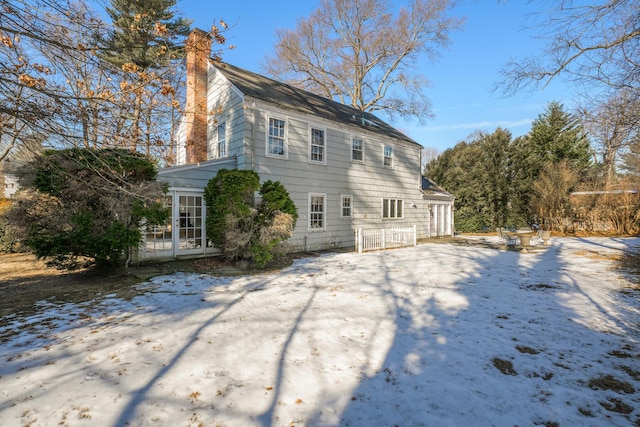 view of snow covered rear of property