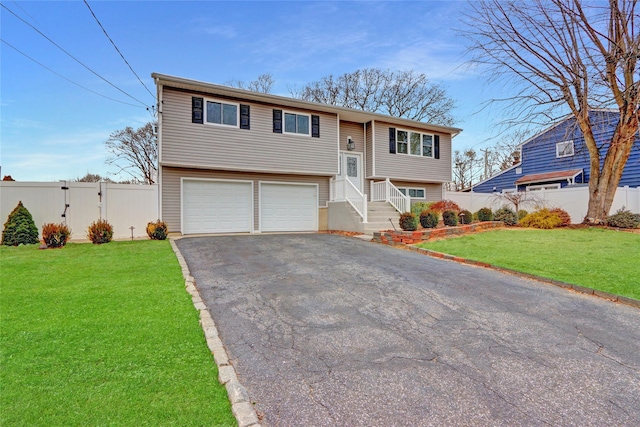 raised ranch featuring a garage and a front yard