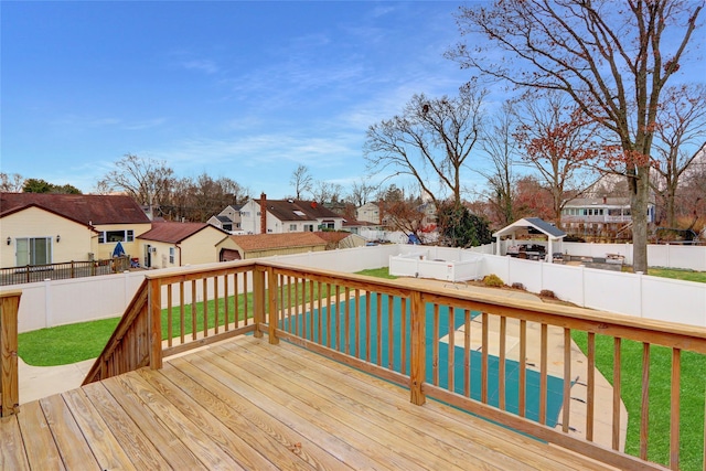 wooden terrace featuring a swimming pool and a lawn