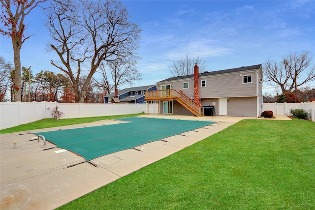 view of swimming pool featuring a patio area, a wooden deck, and a yard