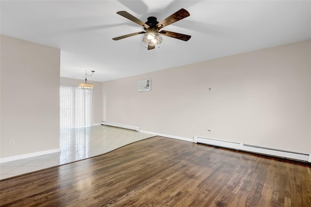 tiled spare room with ceiling fan and a baseboard heating unit