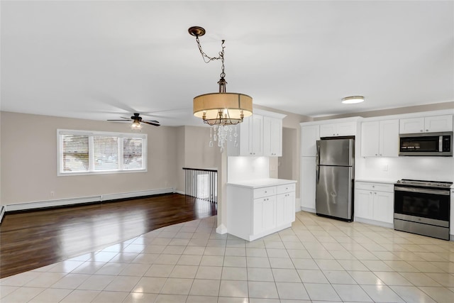 kitchen featuring a baseboard radiator, hanging light fixtures, appliances with stainless steel finishes, white cabinetry, and light tile patterned flooring