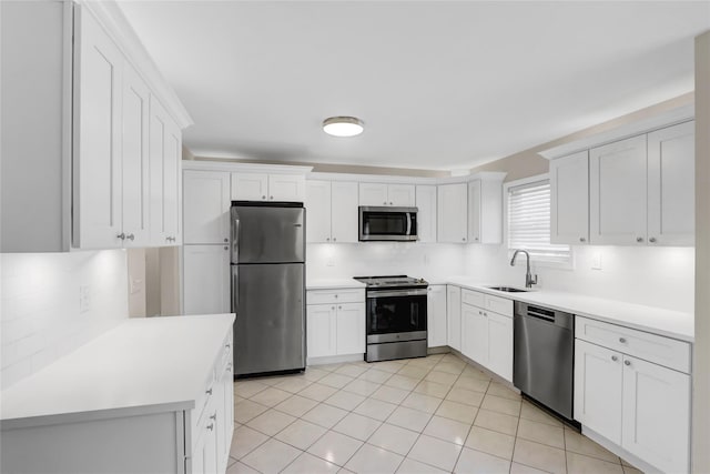 kitchen featuring white cabinetry, stainless steel appliances, tasteful backsplash, sink, and light tile patterned flooring