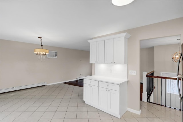 kitchen with white cabinetry, a baseboard heating unit, decorative backsplash, hanging light fixtures, and a notable chandelier