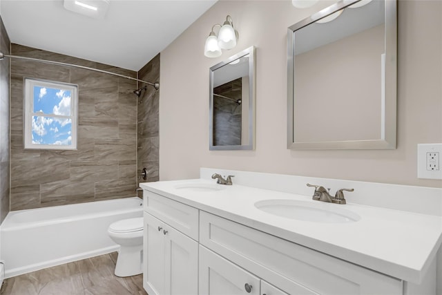 full bathroom with toilet, vanity, and tiled shower / bath