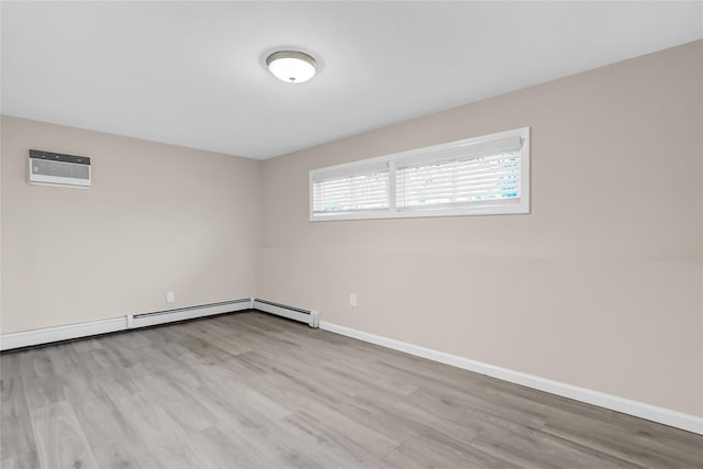 unfurnished room featuring an AC wall unit, baseboard heating, and light hardwood / wood-style flooring