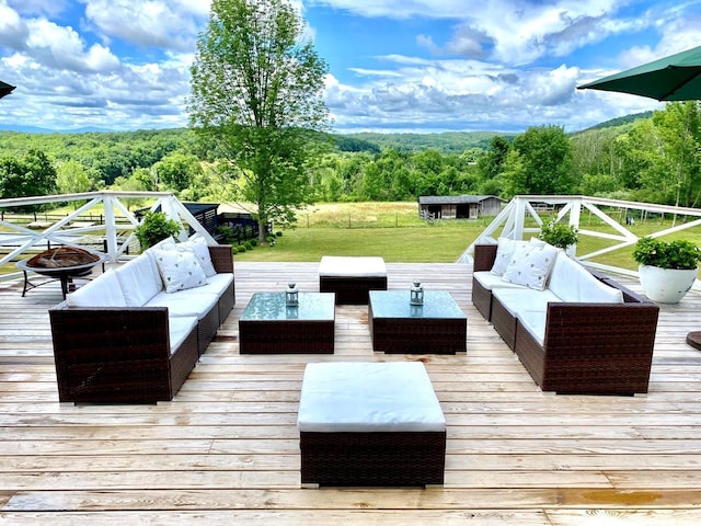 wooden deck with a shed and an outdoor living space with a fire pit