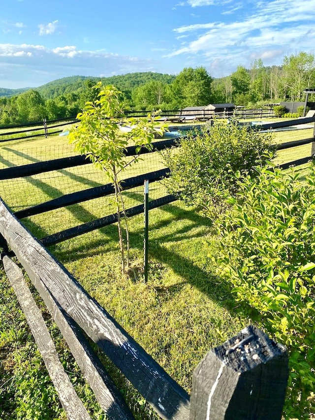 view of gate with a rural view and a yard