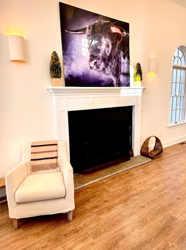 sitting room featuring visible vents, baseboards, wood finished floors, and a fireplace