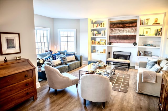 living room with built in features and hardwood / wood-style floors